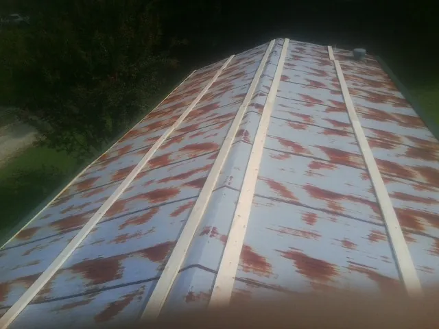 Rusted metal roof panels with new wood purlins before replacement — Storm Damage Roof Repair in Mentcle by Roofing Brothers
